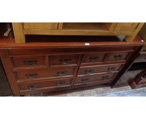 A 4' 11" modern stained wood chest with four short drawers over two pairs of longer drawers under, set on pierced apron and s