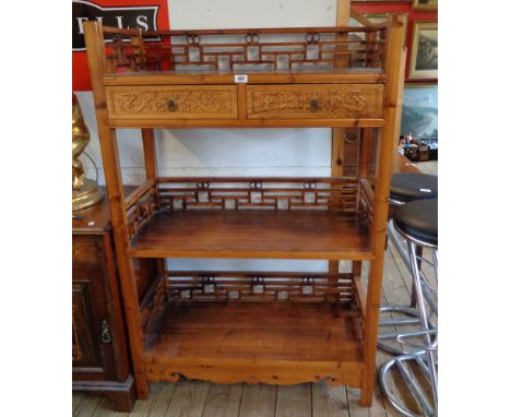 A 36" Chinese lacquered wood three shelf open unit with pierced fence pattern galleries and two frieze drawers, set on shaped