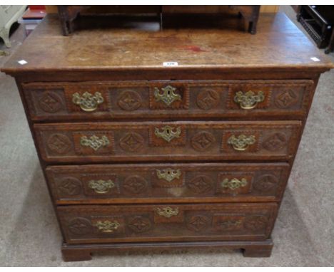 A 34 1/2" antique oak chest of four long graduated drawers with profuse later carved decoration, set on bracket feet