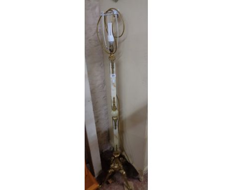An ornate cast brass and onyx standard lamp with shade and caryatid supports