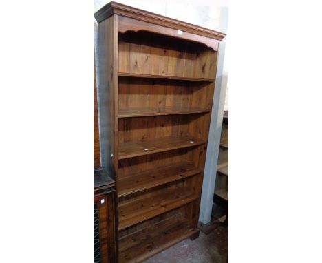 A 3' 1 1/2" modern stained pine six shelf open bookcase, set on bracket feet