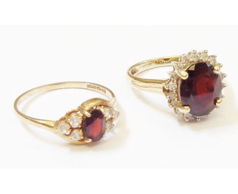 Two British hallmarked 375 gold rings, both set with central garnet within white stone borders