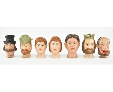 A collection of seven early 20th century continental Black Forest style puppet heads. The puppet heads mostly men with one wo