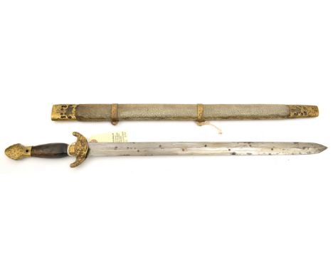 A Chinese sword, DE blade 17½”, inset with copper studs, the hilt with cast brass mounts and plain wood grip, in its brass mo