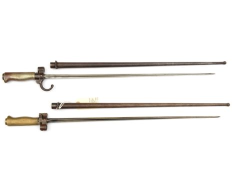 A Lebel bayonet,  WM grip, hooked quillon and another without quillon, both in scabbard. GC, clean examples. 