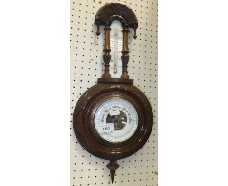 A circa 1900 aneroid barometer thermometer in carved Gothic style frame