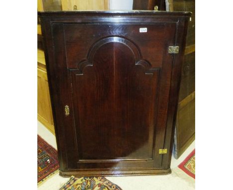 An oak four shelf wall hanging corner cabinet with panelled door