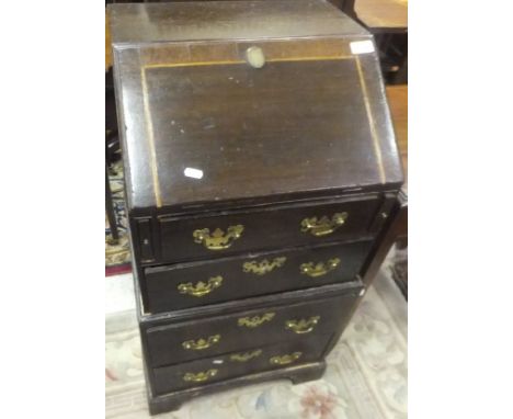 A small 18th Century style oak and cross-banded two section bureau, the rectangular top above a fall front opening to reveal 