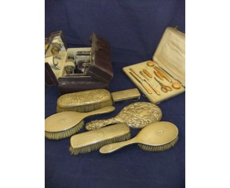 A purple dyed leather lady's travelling vanity case (incomplete), a gold and white enamel decorated manicure set (one pair of