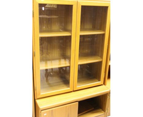 Two teak two-door cupboards with open shelf over, and two teak lounge units, one with two glazed doors enclosing shelves with