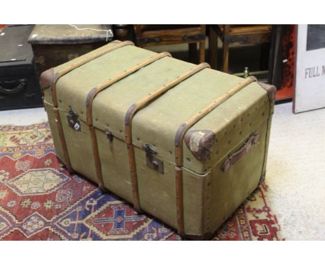 A green canvas and wooden bound steamer trunk CONDITION REPORTS Overall with wear, scuffs, fading, rusting.  Some rips and st