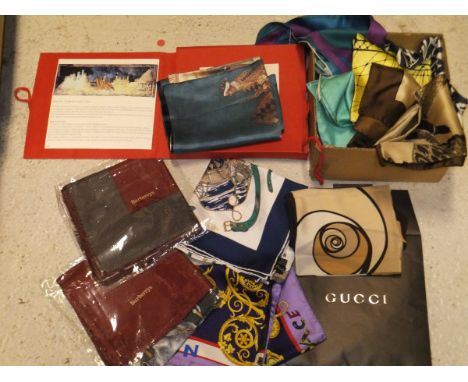 A box containing a Gucci silk scarf in a brown Gucci envelope, a Versace silk scarf inscribed "Art Zoo", four Burberry scarve