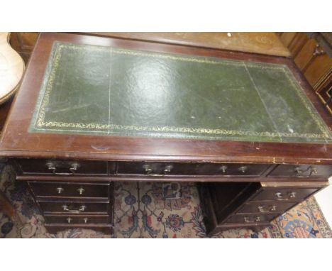 A reproduction mahogany desk, the rectangular top with leather insert above a central drawer flanked by two small drawers ove