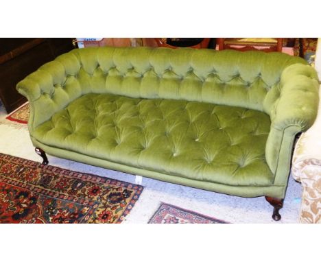 An Edwardian upholstered and button decorated green velvet sofa