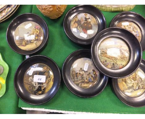 A collection of seven 19th Century Prattware pot lids, each housed in a circular ebonised wooden frame, to include "Derby Day