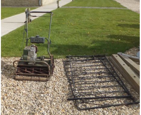 An old petrol garden mower/roller, together with two iron gates