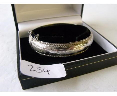 A silver engraved bangle boxed     