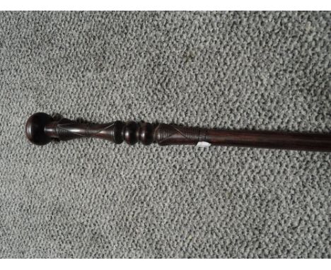 An ethnic hard wood carved walking stick or cane with knopped handle