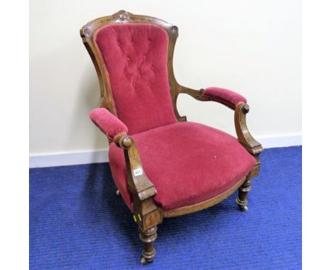 19th century walnut framed button back armchair raised on turned supports.