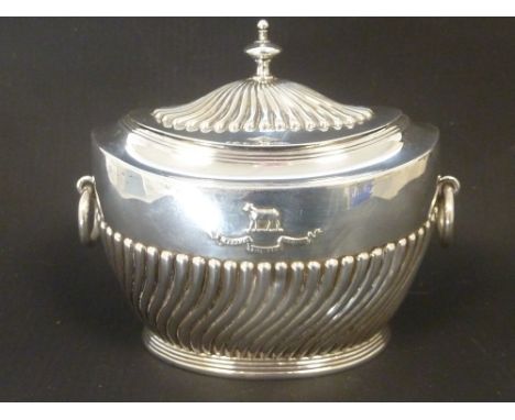 Silver caddy, oval part fluted with embossed crest. Maker Carrington, London 1903. Condition Report. Good condition.Weight: 4
