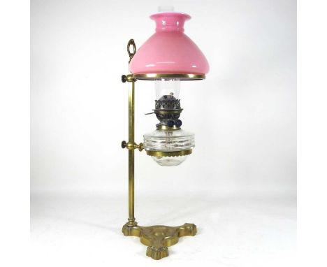 A 19th century brass adjustable student's lamp, with an Everards patent and pink opaque shade and clear glass reservoir, 57cm