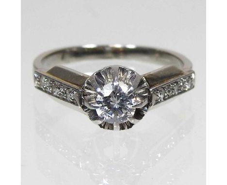 An unmarked diamond cluster ring, approximately 0.2 carat illusion set, with diamond shoulders, 3.1g, size I
