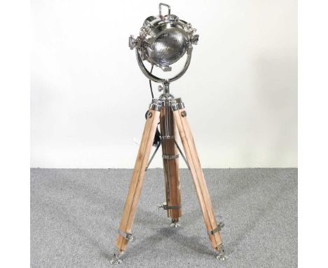 A spotlight floor lamp, on an adjustable tripod stand