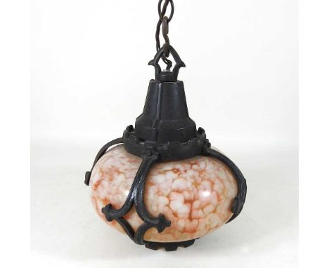 An early 20th century Arts and Crafts cast iron pendant light, with a mottled glass shade, 28cm high