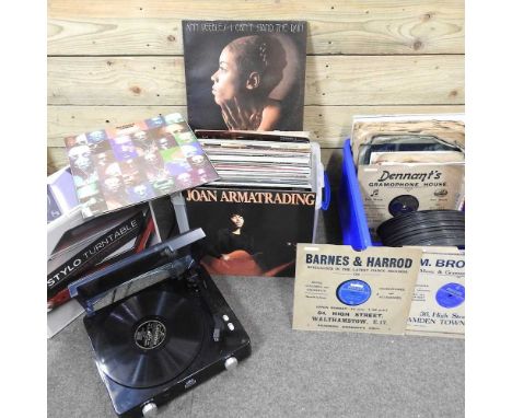 A modern record player, together with a collection of vinyl records