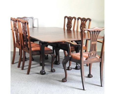 An early 20th century pull out extending dining table, with three additional leaves, on claw and ball feet, together with a n