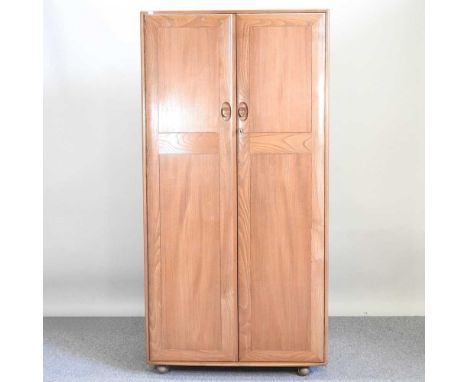 An Ercol light elm Windsor double wardrobe, circa 1970's, enclosed by panelled doors91w x 54d x 182h cmOverall condition is c