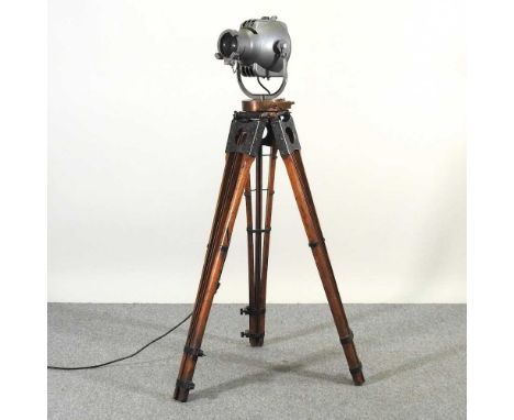 A mid 20th century Strand electric stage light, on a folding wooden tripod stand, 138cm high