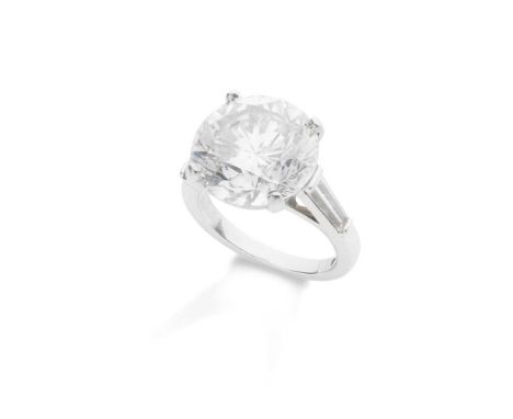 The brilliant-cut diamond in a four-claw mount, between tapered baguette-cut diamond shoulders  Ring size: L/M