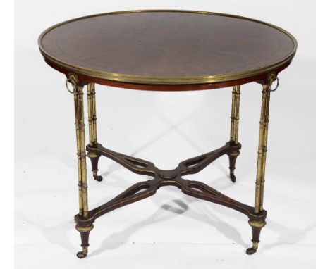 A FRENCH MAHOGANY CIRCULAR CENTRE TABLE the top with brass surround, ebony line inlay and radiating veneers on four brass twi