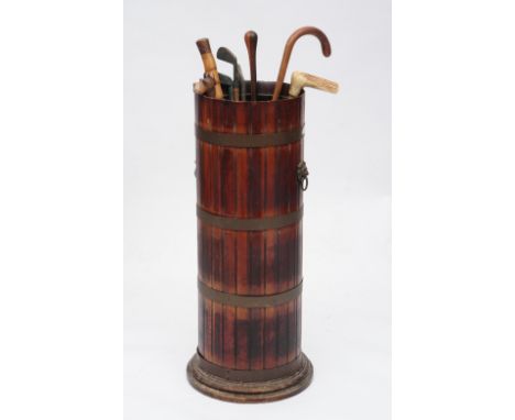 A COOPERED AND BRASS BOUND CYLINDRICAL STICK STAND with lion head ring handles, 77cm high, together with walking sticks and g