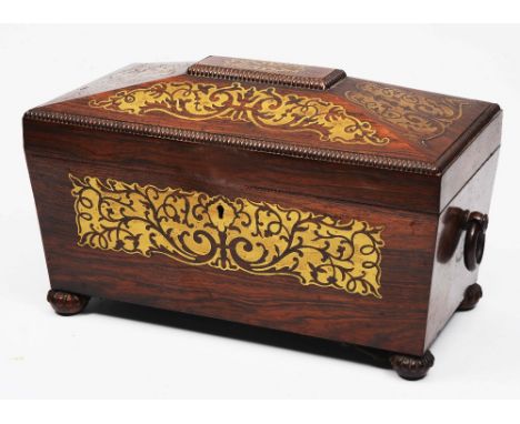 AN EARLY VICTORIAN ROSEWOOD AND BRASS INLAID TEA CADDY of sarcophagus form fitted with two removable lidded compartments on l