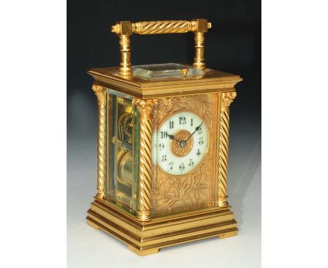 A FRENCH CARRIAGE CLOCK with white enamel Gothic numeral dial, having a foliate mask, the movement with coiled gong strike, p