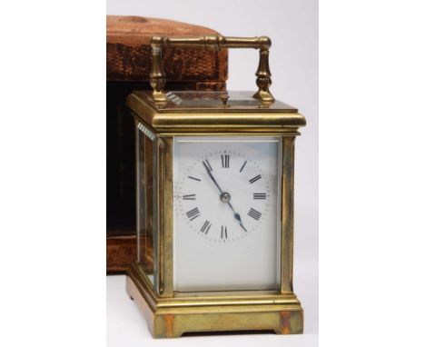 A LATE 19TH CENTURY FRENCH BRASS CARRIAGE CLOCK with white enamel dial, the movement striking on a gong and with push repeat,