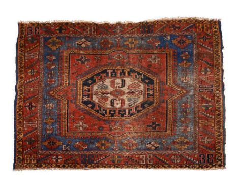 AN OLD KAZAK SQUARE RUG with a central hooked octagonal medallion with inner blue ground border and rust surround 185cm squar