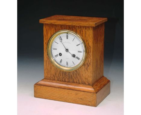 AN OAK MANTEL CLOCK the circular white enamel dial signed Charles Frodsham, London with striking French movement 23cm high 