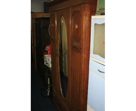 AN OAK MIRRORED SINGLE DOOR WARDROBE, and an oak dressing table with oval mirror (in isle opposite)