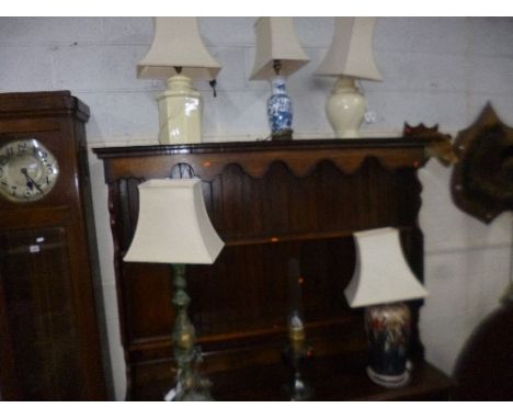 A PAINTED BRASS TABLE LAMP, with a shade, four ceramic table lamps with shades and an oil lamp (6)