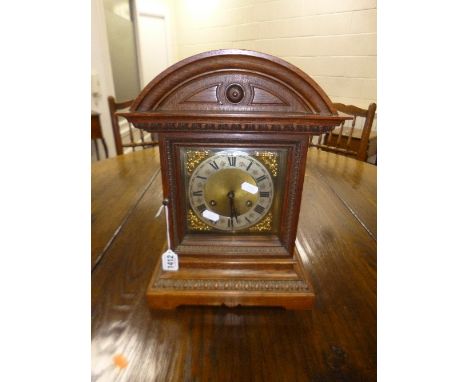 AN EDWARDIAN OAK STRIKING BRACKET CLOCK, brass dial with Roman numerals, approximate size width 28cm x height 38cm x depth 18