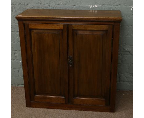 A C20th mahogany two door cupboard with key.
