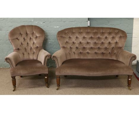 A deep buttoned two seat sofa upholstered in fawn draylon and matching spoon back arm chair raised on turned oak castered leg