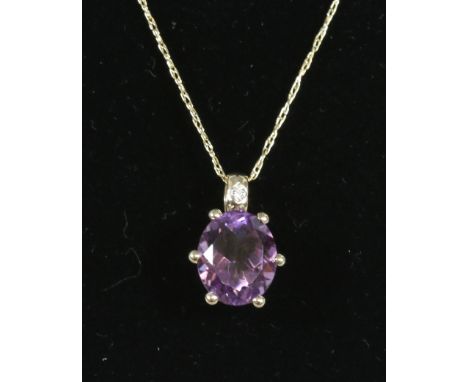 A 9ct gold pendant set with an amethyst and diamond. 
