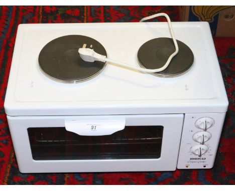 A Beko compact cooker with manual.