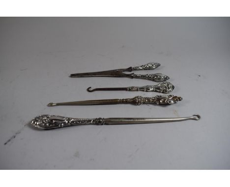 A Collection of Three Silver Handled Button Hooks and a Glove Stretcher 