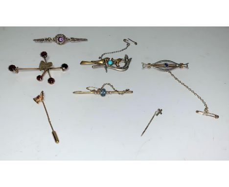 An Edwardian bar brooch set sapphire and seed pearls, stamped '15c'; a yellow metal bar brooch set garnets in the form of the