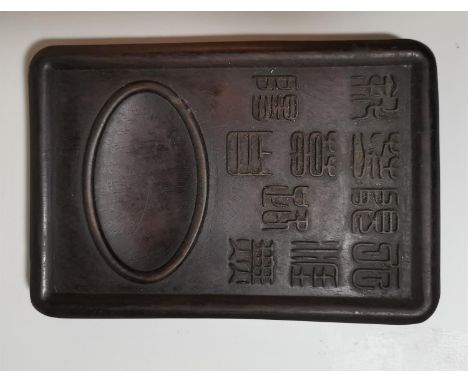 A Chinese carved hardwood ink palette with raised seal characters and oval reservoir, 20 x 14 cm 